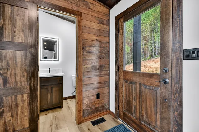 a view of a hallway with a door and wooden floor