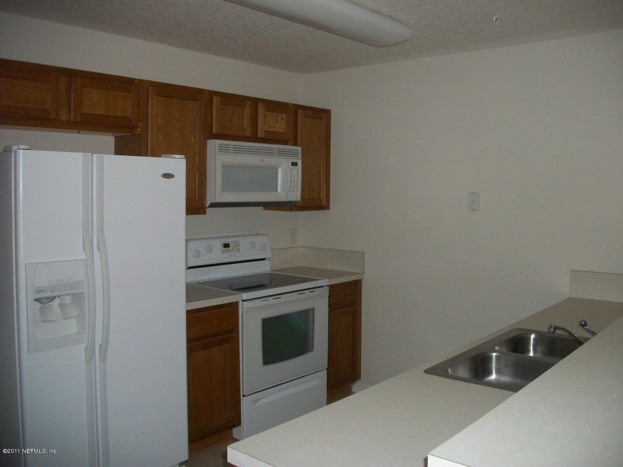 7920 Merrill Road, Unit 1511 Jacksonville, FL 32277 - Photo 3 of 11 a kitchen with stainless steel appliances a stove a microwave and a refrigerator