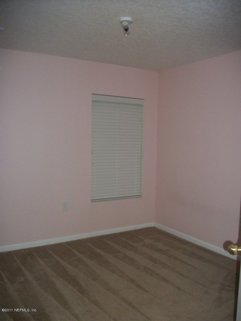 7920 Merrill Road, Unit 1511 Jacksonville, FL 32277 - Photo 5 of 11 a view of an empty room with wooden floor and a window