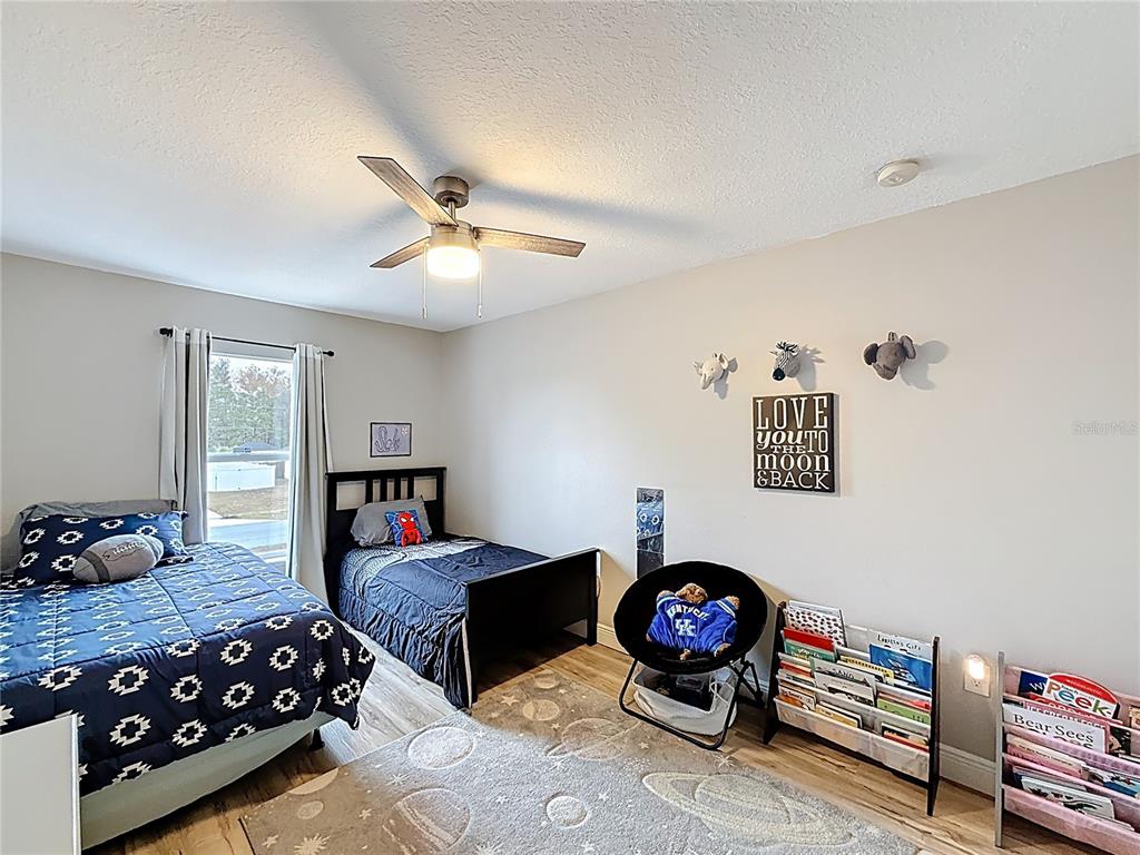 14908 Southwest 46th Circle Ocala, FL 34473 - Photo 27 of 46 a bedroom with bed and a chandelier