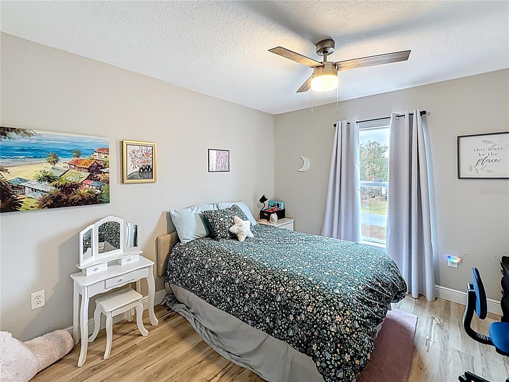 14908 Southwest 46th Circle Ocala, FL 34473 - Photo 29 of 46 a bedroom with a bed painting on wall and a large window