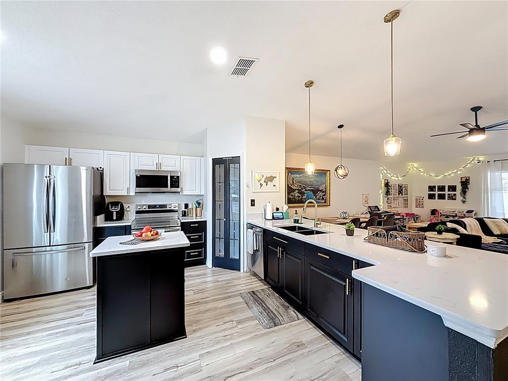 14908 Southwest 46th Circle Ocala, FL 34473 - Photo 5 of 46 a kitchen with stainless steel appliances kitchen island granite countertop a sink stove and refrigerator