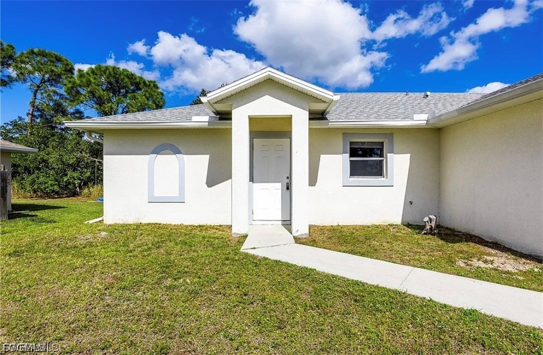 4716 1st Street Southwest Lehigh Acres, FL 33973 - Photo 1 of 20 a front view of a house with a yard and garage