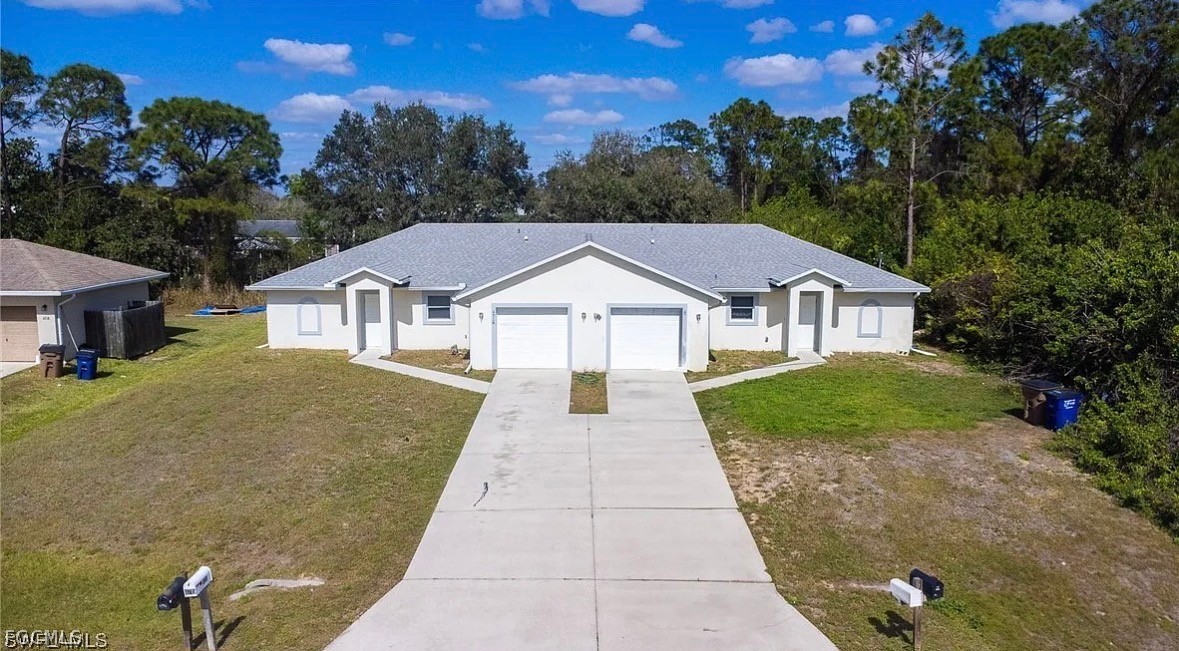 4716 1st Street Southwest Lehigh Acres, FL 33973 - Photo 2 of 20 a front view of a house with garden