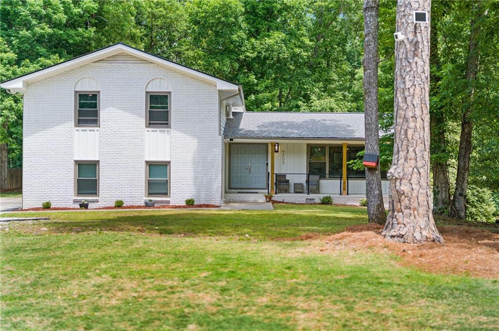 4205 South Berkeley Lake Road Northwest Berkeley Lake, GA 30096 - Photo 2 of 34 a front view of a house with a yard
