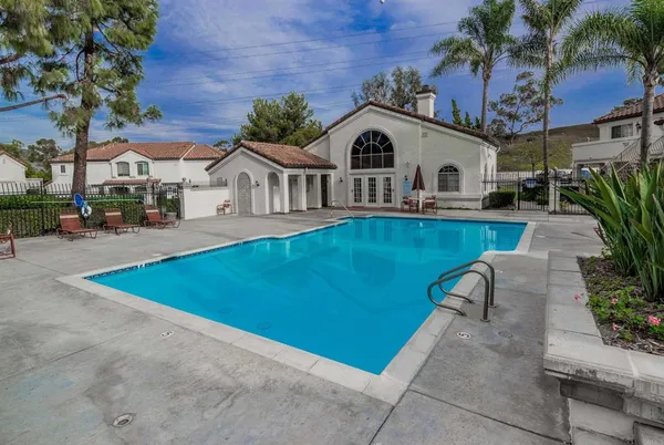 a view of a house with pool and chairs