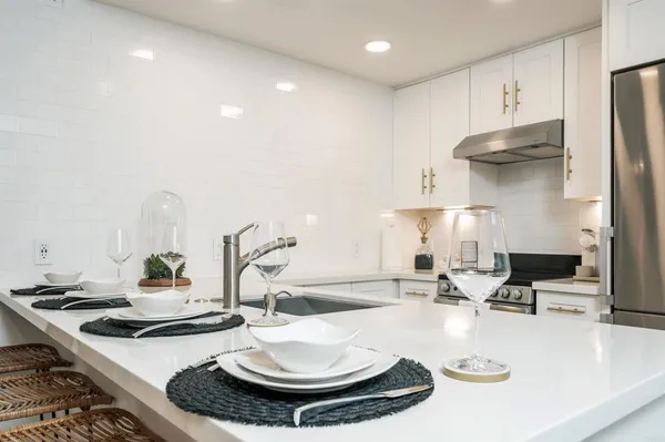 a kitchen with a stove a sink and a dining table