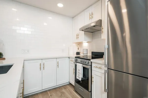 a kitchen with a stove top oven and cabinets