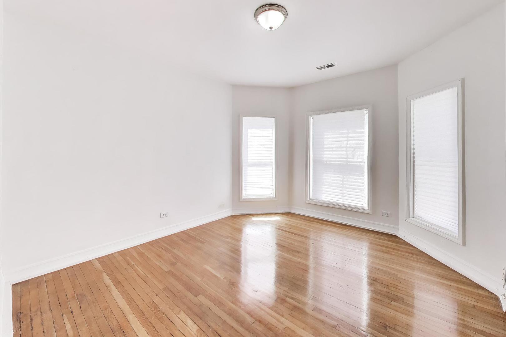 6853 South Perry Avenue Chicago, IL 60621 - Photo 16 of 28 a view of an empty room with wooden floor and a window