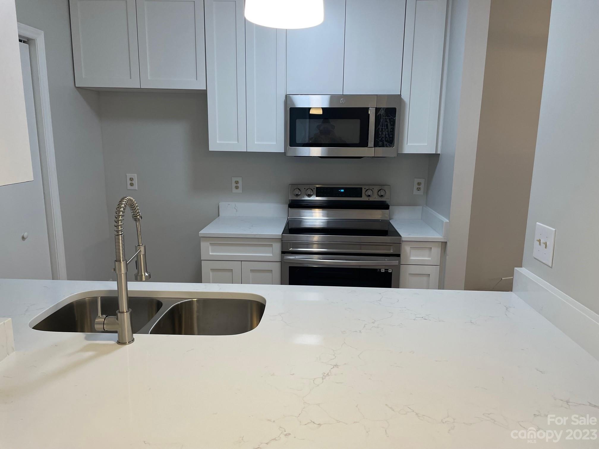 11011 Harrowfield Road Charlotte, NC 28226 - Photo 6 of 24 a kitchen with stainless steel appliances a stove a microwave a sink a refrigerator and cabinets