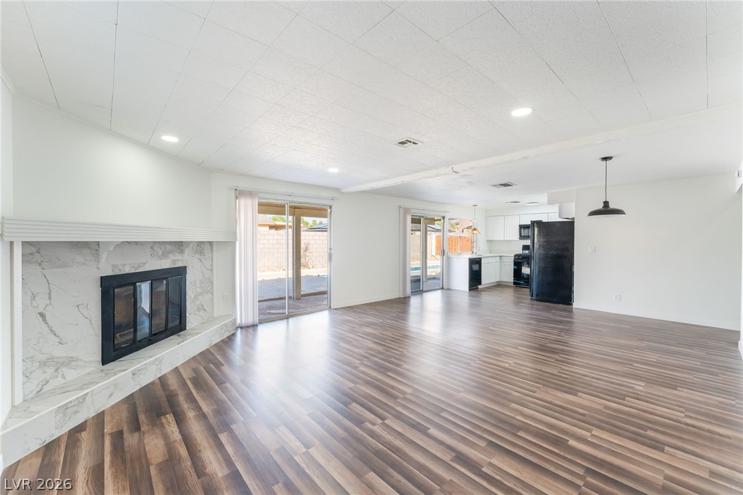 3597 Bronco Road Las Vegas, NV 89103 - Photo 9 of 43 great/ living room featuring dark wood-style floors, a fireplace, and recessed lighting Large room to entertain.