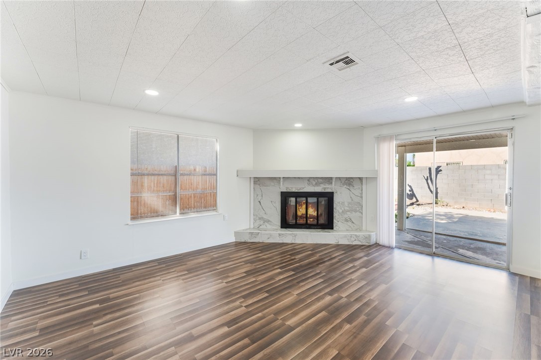3597 Bronco Road Las Vegas, NV 89103 - Photo 10 of 43 great/ living room with dark wood-style flooring, a high end fireplace, and recessed lighting. Cozy up to the fireplace.