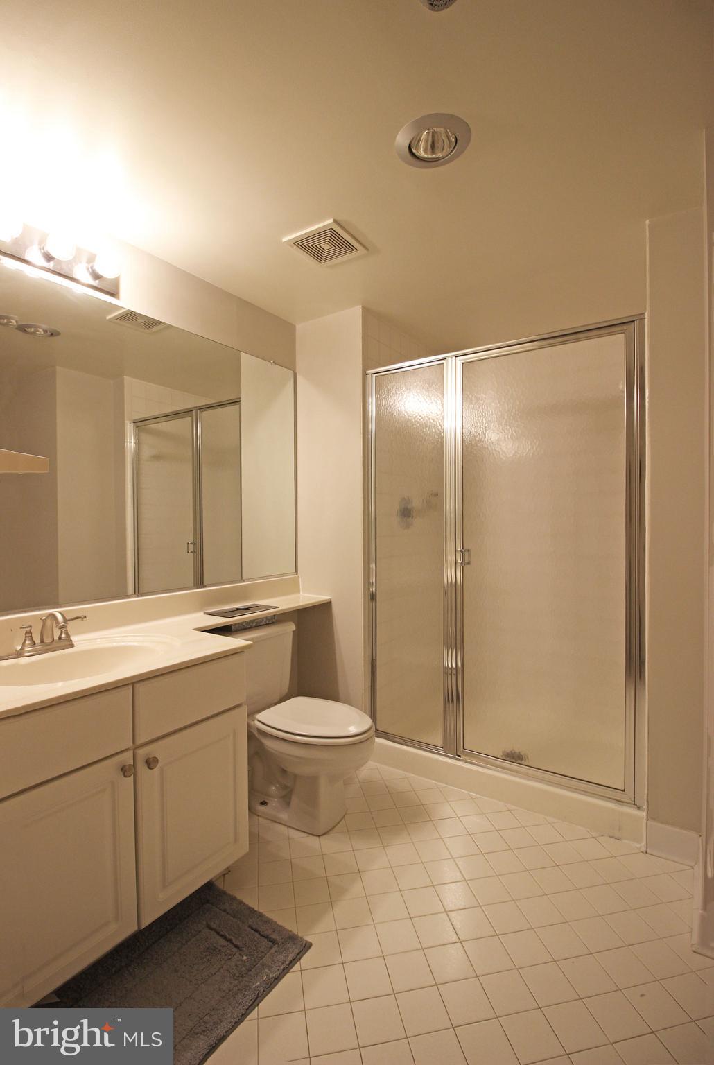 1045 North Utah Street, Unit 108 Arlington, VA 22203 - Photo 12 of 22 a bathroom with a double vanity sink toilet and shower
