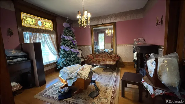 a living room with furniture a chandelier and a flat screen tv