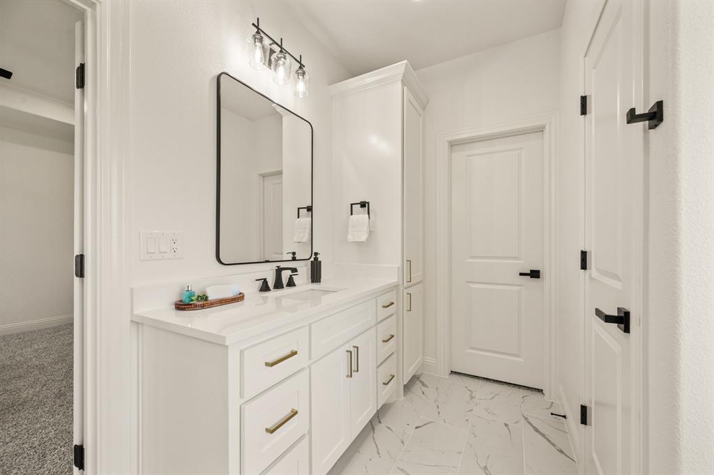 2705 Gospel Road Tolar, TX 76476 - Photo 21 of 36 Bathroom featuring a white vanity with gold-tone hardware, a rectangular sink, and a matte black faucet