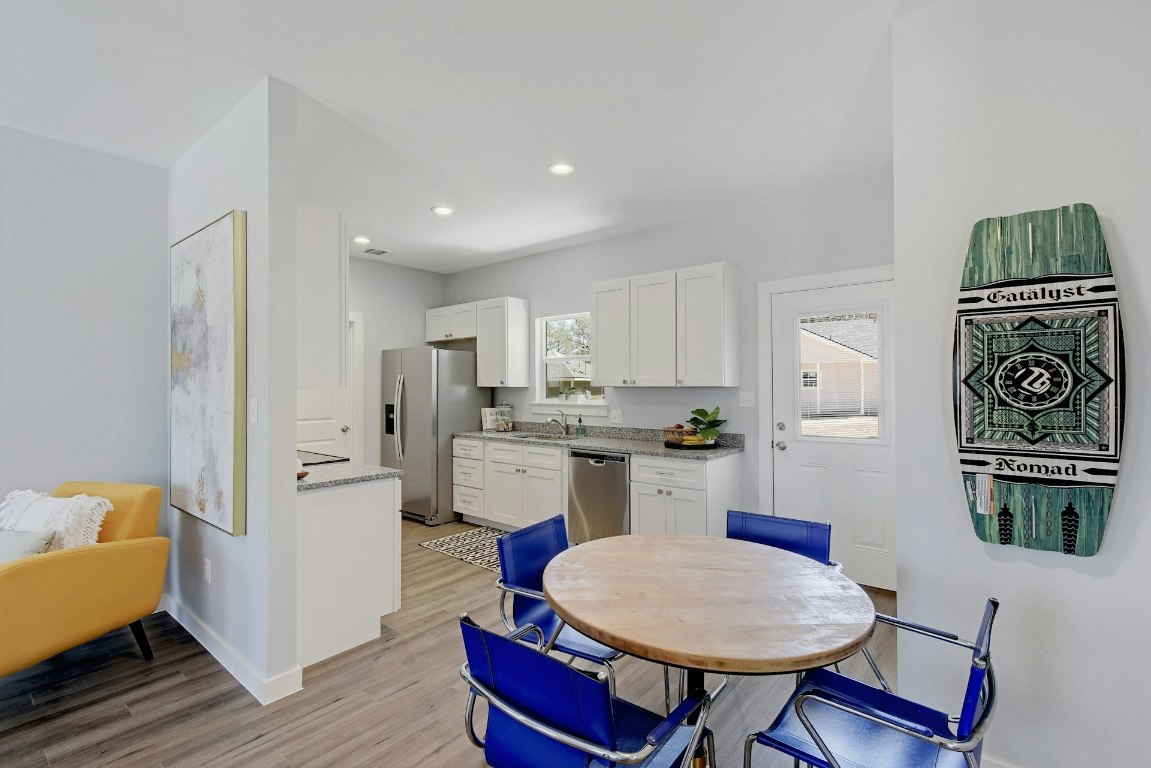 14922 Running Deer Trail Austin, TX 78734 - Photo 21 of 31 a kitchen with stainless steel appliances granite countertop a dining table chairs and a refrigerator