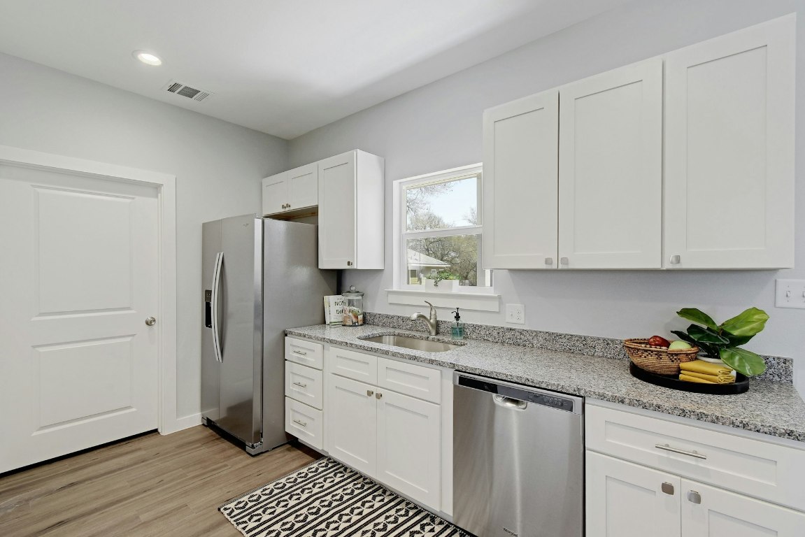 14922 Running Deer Trail Austin, TX 78734 - Photo 18 of 31 a kitchen with stainless steel appliances white cabinets sink and window