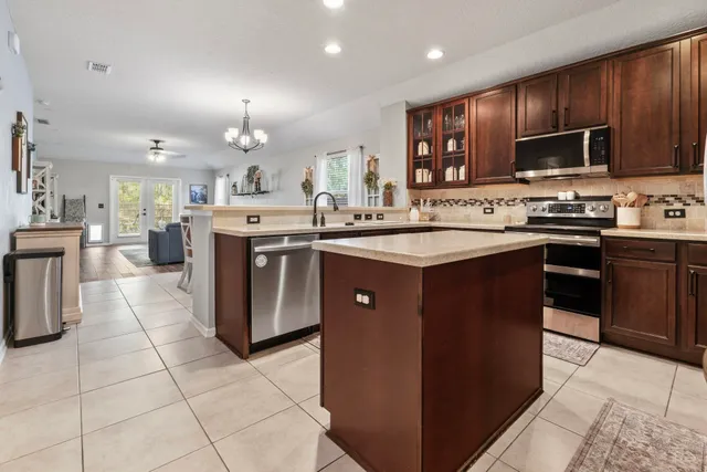 a kitchen with stainless steel appliances granite countertop a refrigerator stove a sink dishwasher and microwave with wooden cabinets