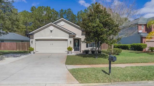 a view of a house with a yard and garage