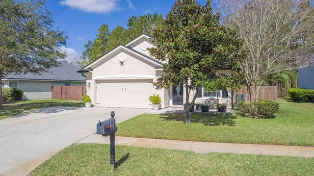 an aerial view of house with yard and trees in the background