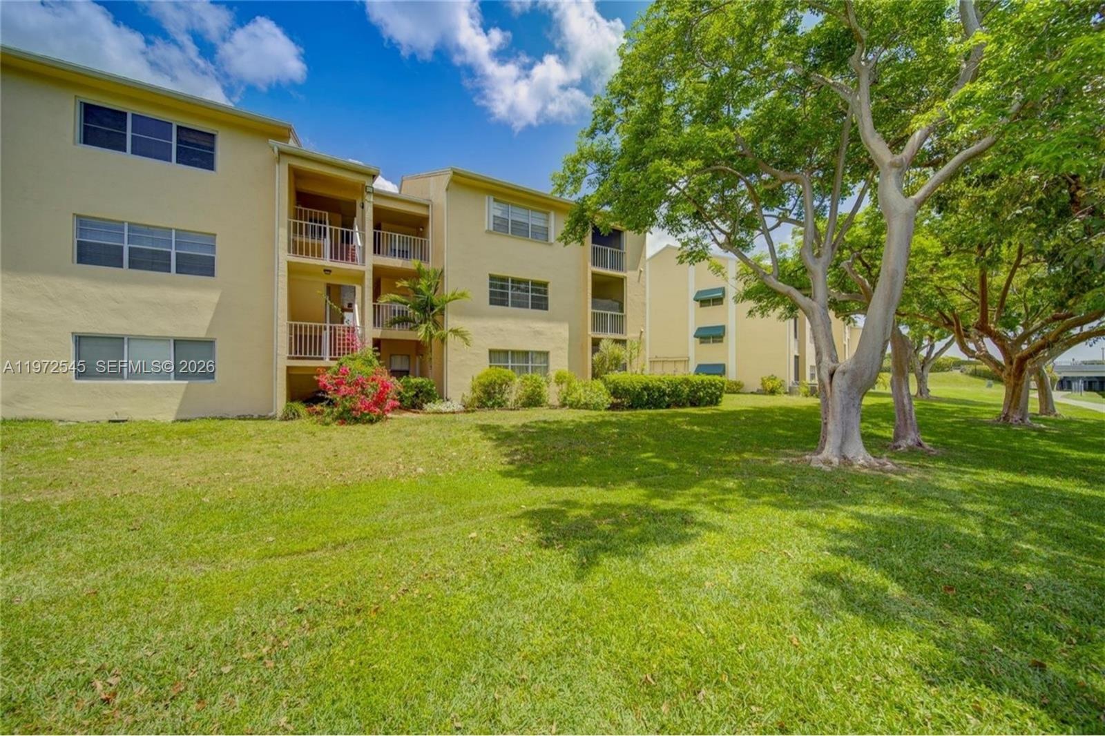 15285 Southwest 107th Lane, Unit 201 Miami, FL 33196 - Photo 13 of 28 a view of a house with a big yard and large trees