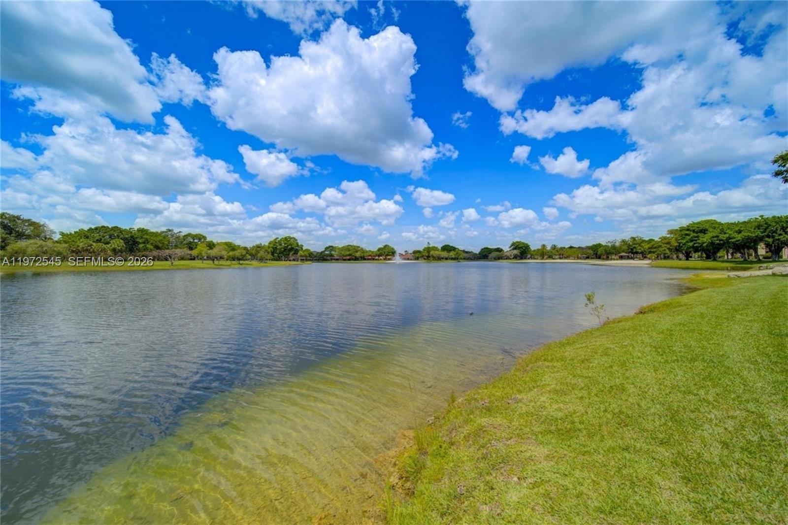 15285 Southwest 107th Lane, Unit 201 Miami, FL 33196 - Photo 21 of 28 a view of a lake with houses in the background