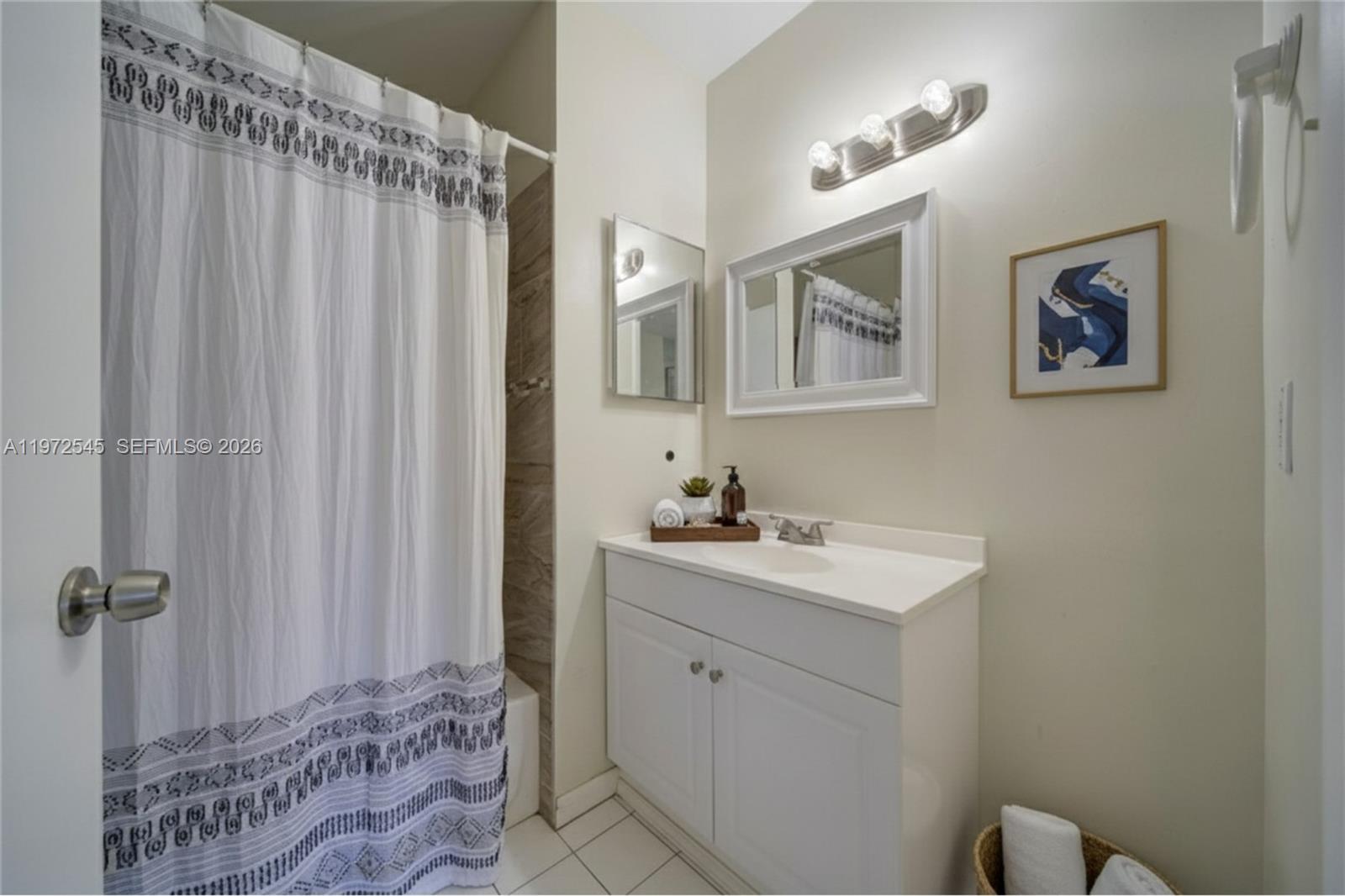 15285 Southwest 107th Lane, Unit 201 Miami, FL 33196 - Photo 6 of 28 a bathroom with a sink a mirror and a shower