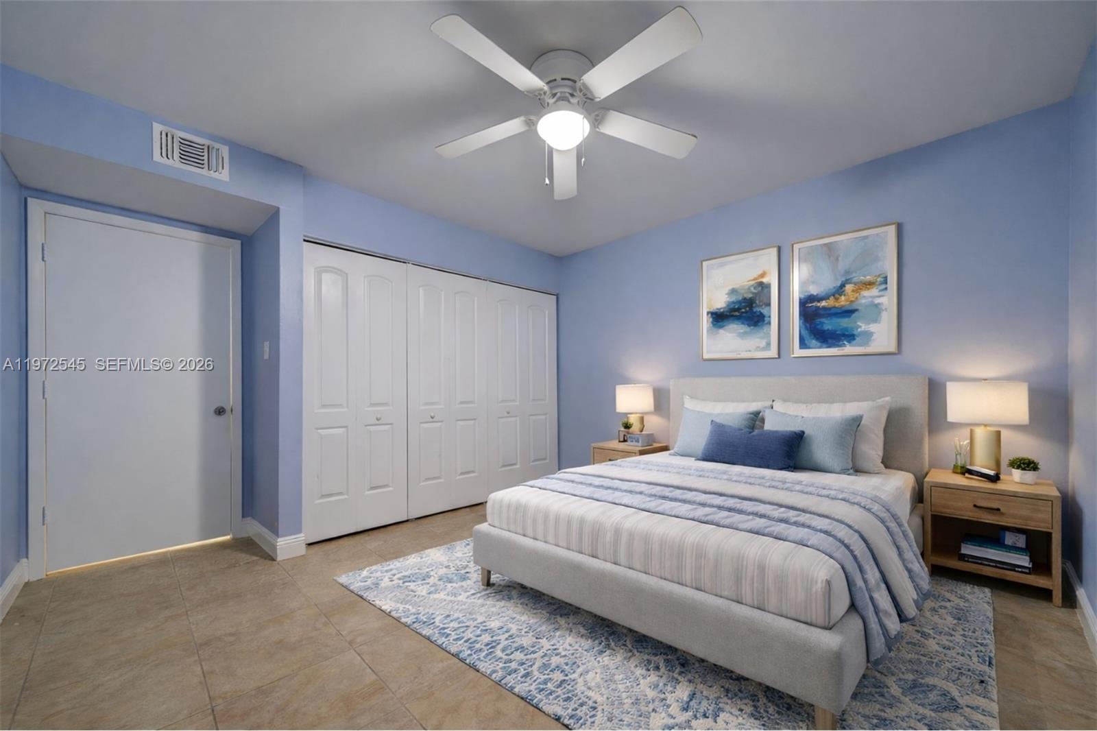 15285 Southwest 107th Lane, Unit 201 Miami, FL 33196 - Photo 8 of 28 a bedroom with a large bed and a chandelier