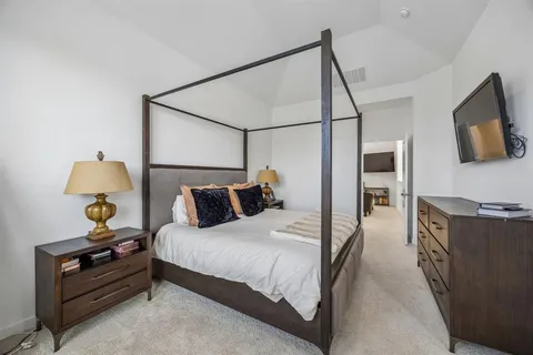 a bedroom with bed and a flat tv screen on a dresser