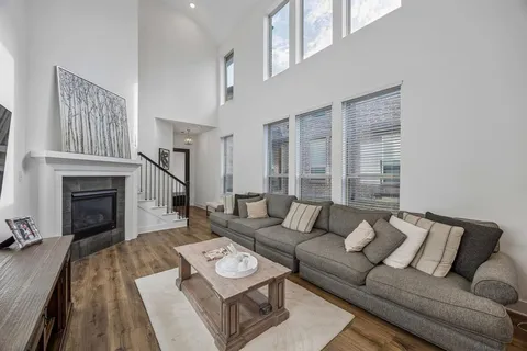 a living room with furniture a fireplace and a large window