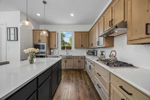 a kitchen with stainless steel appliances sink stove microwave and cabinets