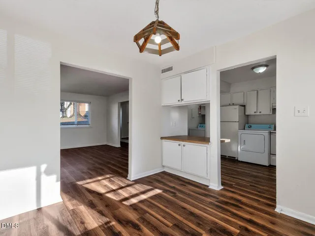 a kitchen view with wooden floor and a refrigerator