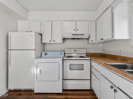 a kitchen with cabinets and a refrigerator