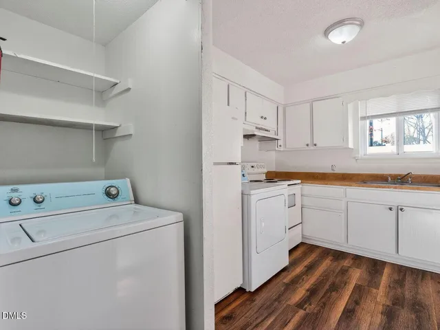 a kitchen with cabinets appliances a sink and a window