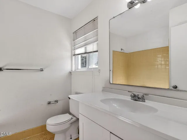 a bathroom with a sink a toilet and a mirror