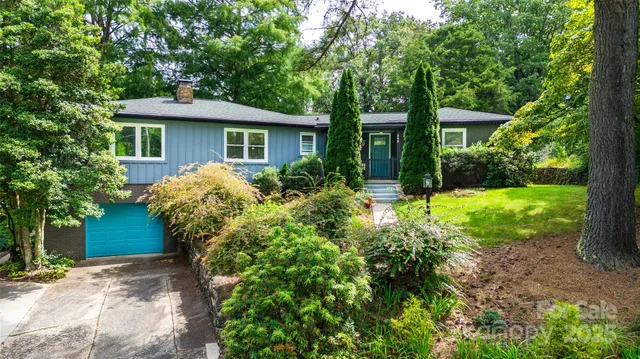 a view of a house with a yard and potted plants