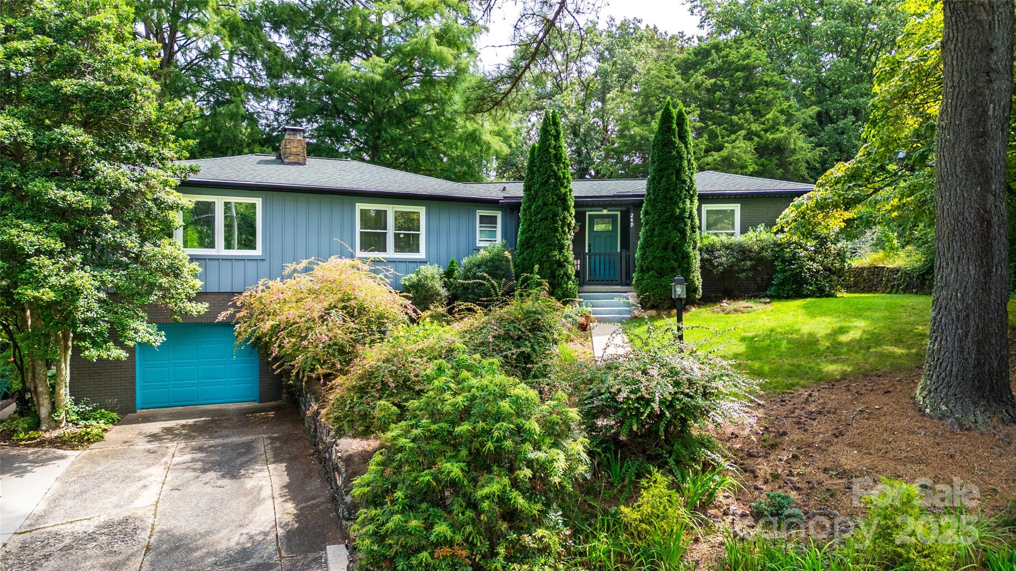 a view of a house with a yard and potted plants