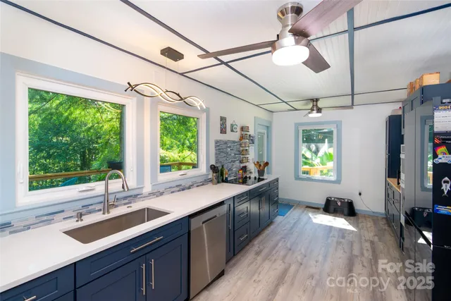 a kitchen with granite countertop a sink appliances cabinets and a large window