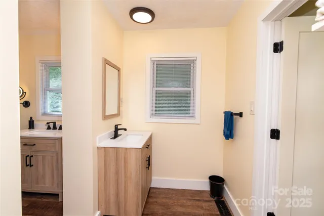 a bathroom with a sink a window and a mirror