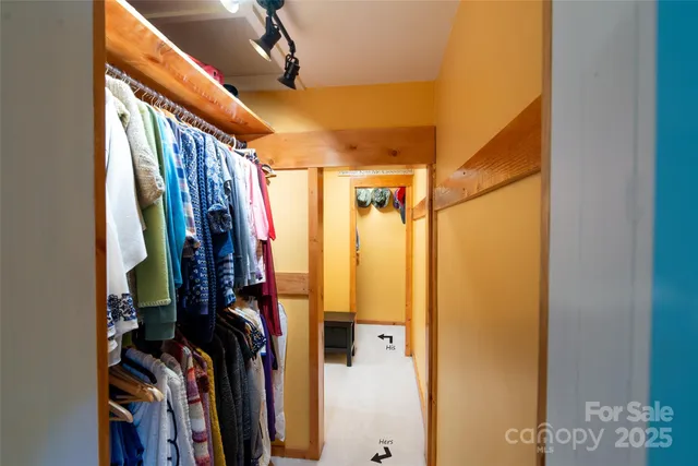 a view of walk in closet with clothes and shoes