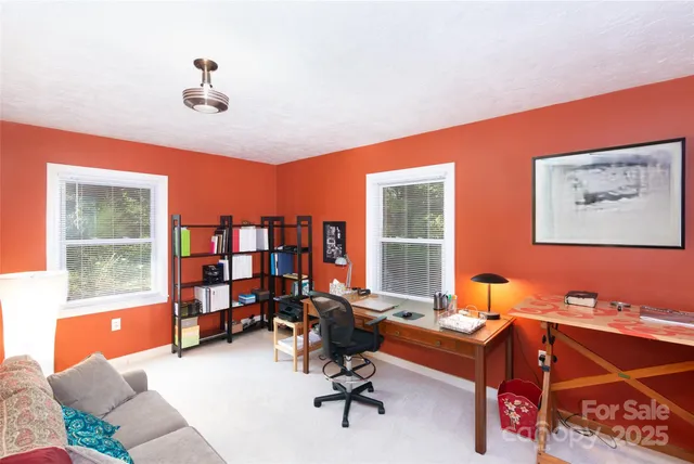 a view of a workspace with furniture and a window