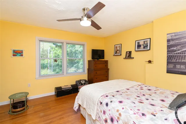 a bedroom with a bed and wooden floor