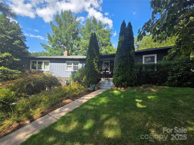 a view of a house with a yard and potted plants