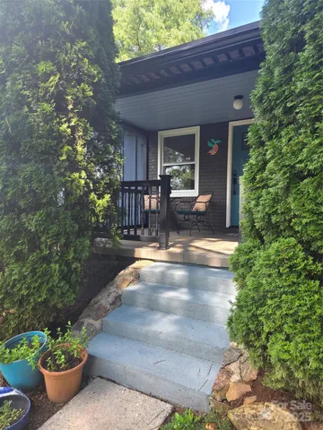 a view of a patio with chairs and potted plants