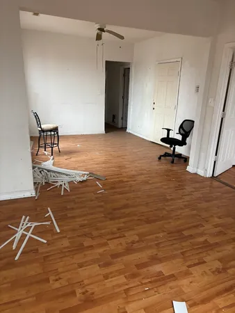 a view of a room with wooden floor and a ceiling fan