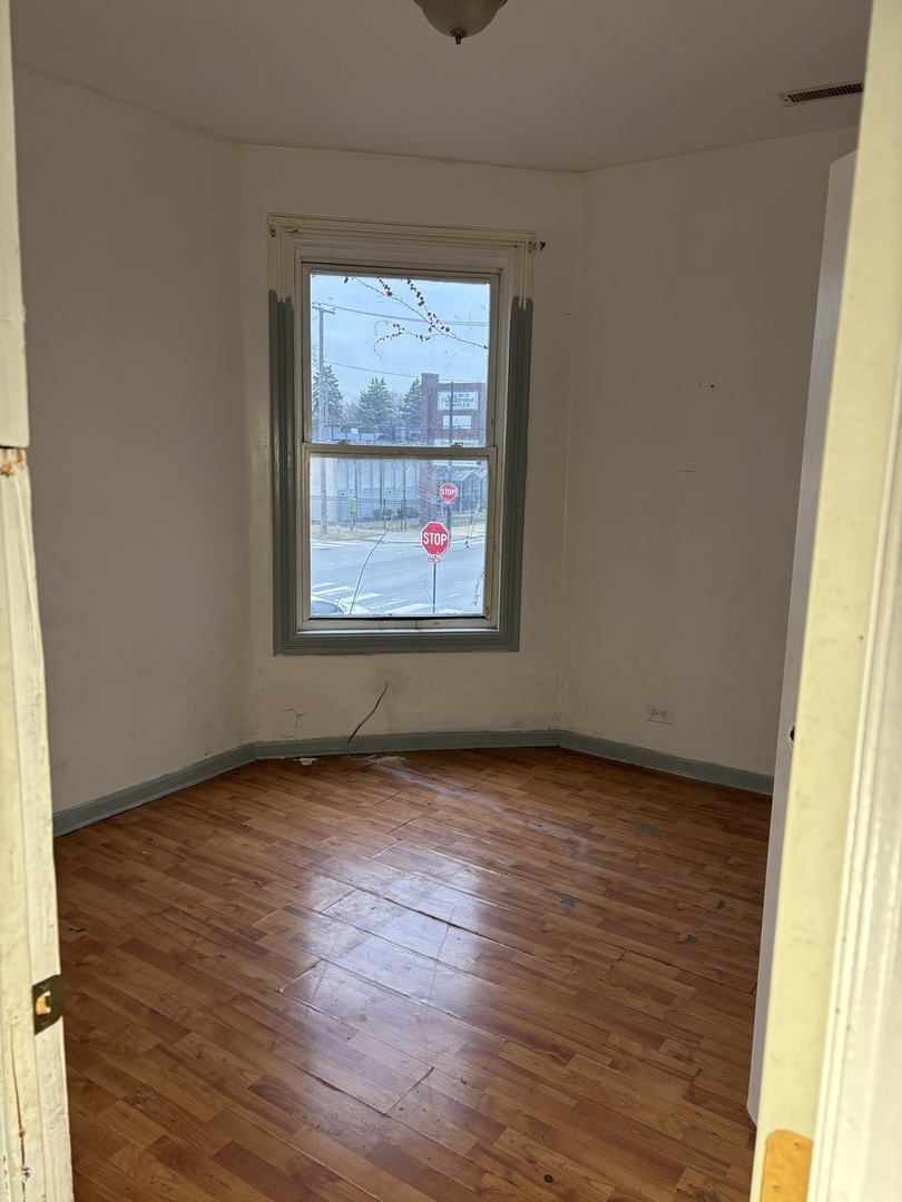539 West 119th Street Chicago, IL 60628 - Photo 14 of 19 an empty room with wooden floor and windows