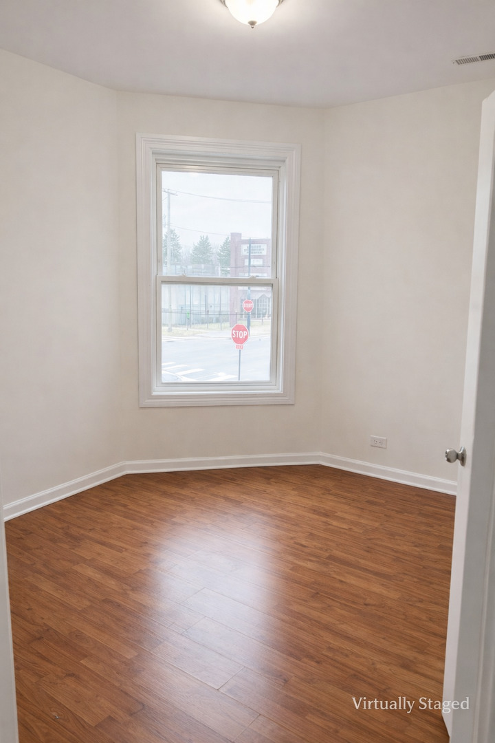 539 West 119th Street Chicago, IL 60628 - Photo 15 of 19 an empty room with wooden floor and windows