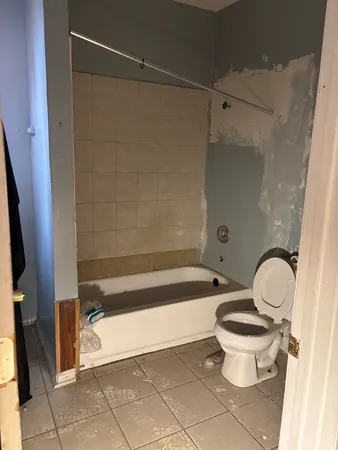a bathroom with a bathtub a toilet and a shower