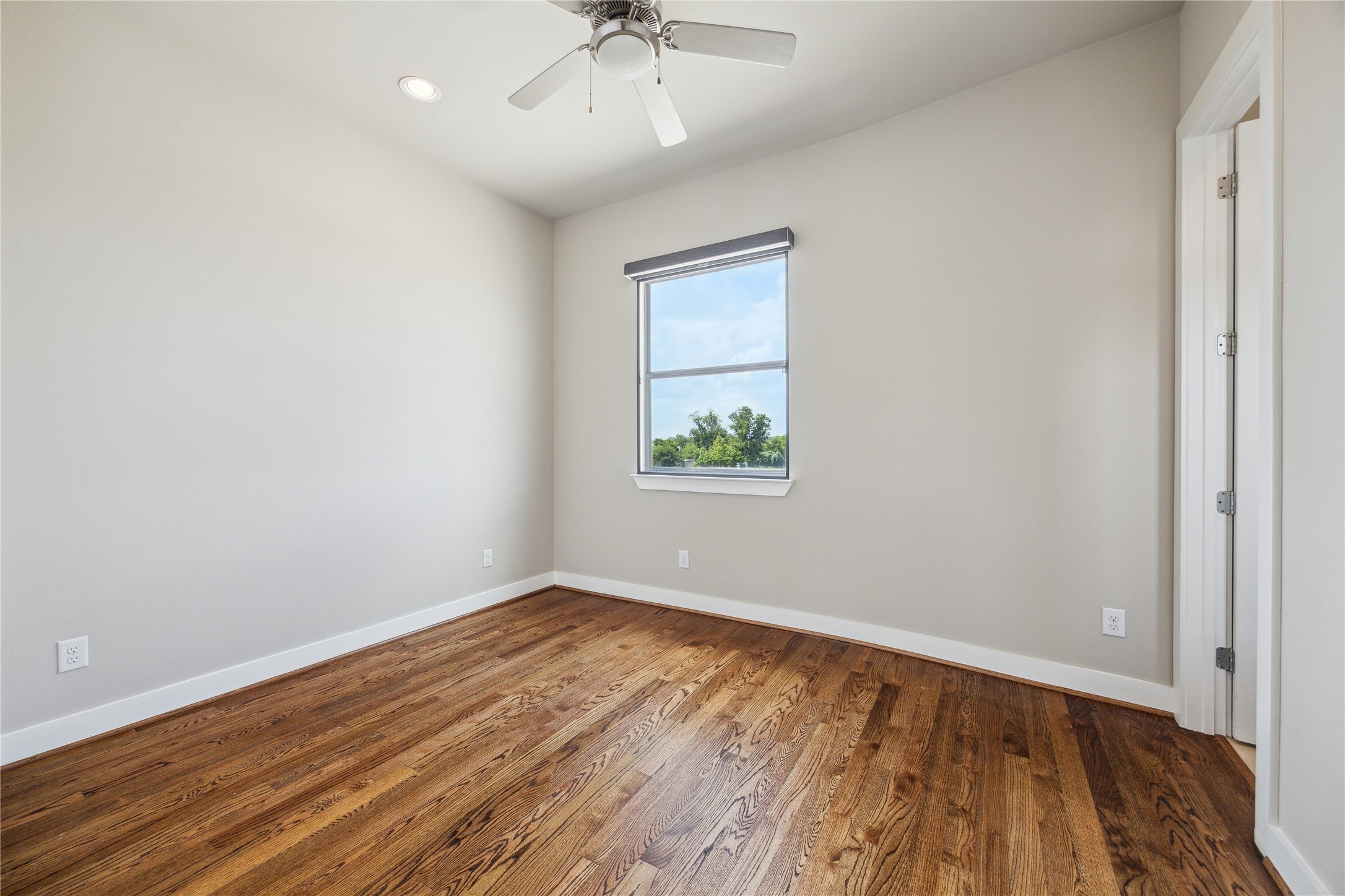4102 Marina Street Houston, TX 77007 - Photo 16 of 23 an empty room with wooden floor chandelier fan and windows