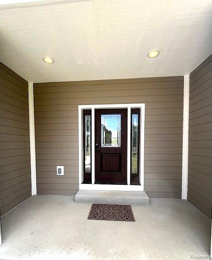 2670 Riley Center Road Memphis, MI 48041 - Photo 3 of 24 Covered entryway with recessed lighting, horizontal siding, and a dark wood-finish door with decorative glass